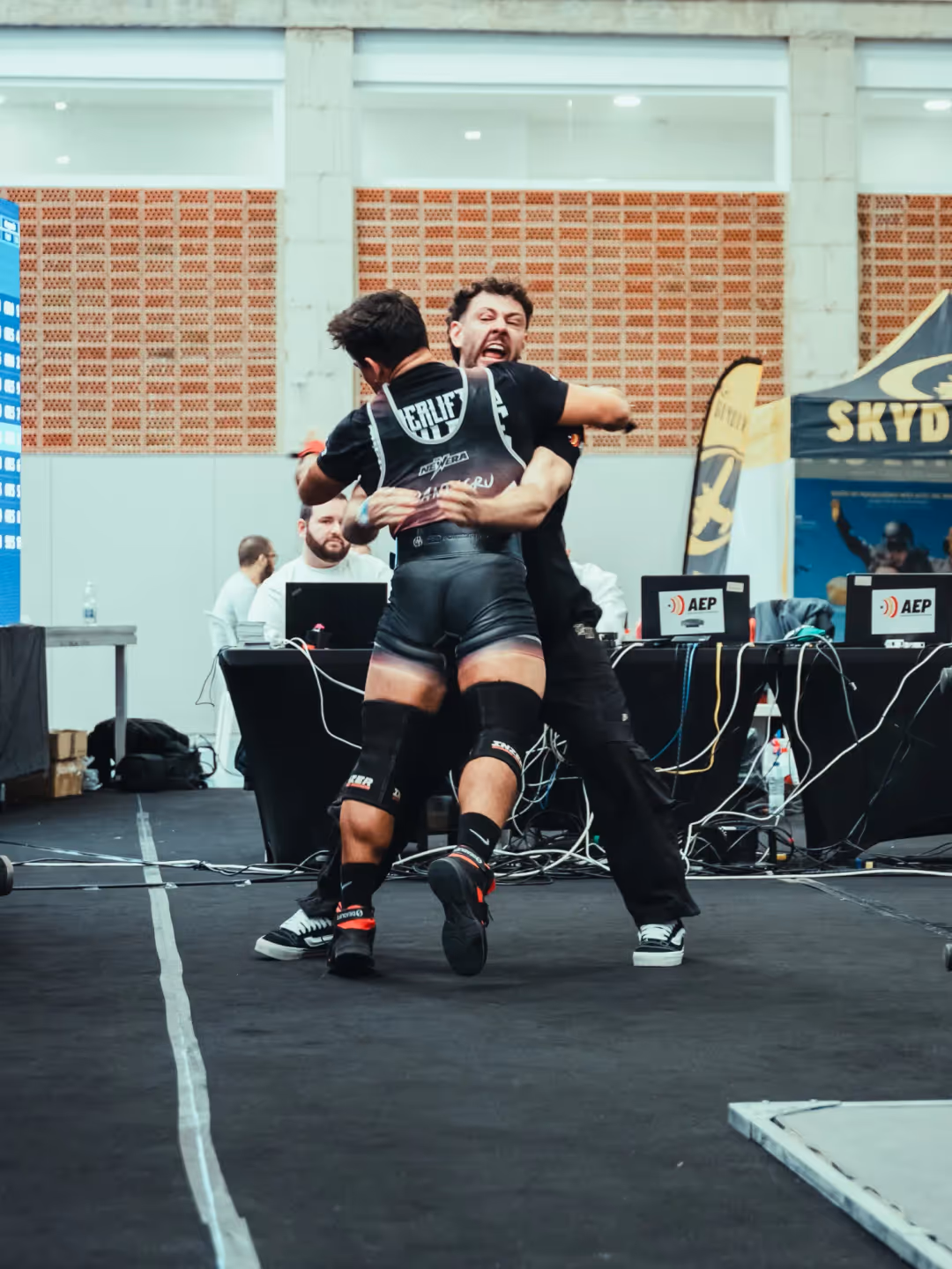Atleta asesorado ejecutando una sentadilla en competición